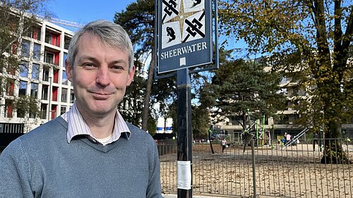 Will Forster standing in front of Sheerwater sign