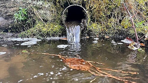 Sewerage pipe emptying into river