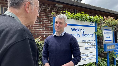 Will Forster outside Woking Community Hospital talking to a resident